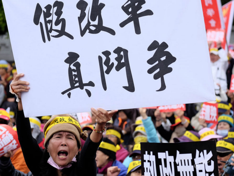 　　这次抗议由“监督年金改革行动联盟”、台湾退休教师联盟等团体发起。他们高喊“执政无能”“毁约背信”“假改革，真斗争”“反污名，要尊严”等口号，希望将不满和愤怒传进不远处的台当局领导人办公场所。图为抗议现场。