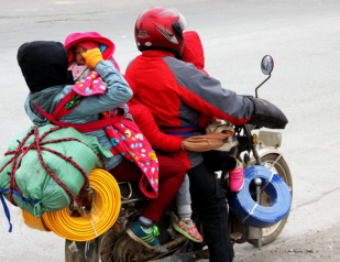 一辆摩托乘五人＂虎爸虎妈＂驮三子女赶赴广东