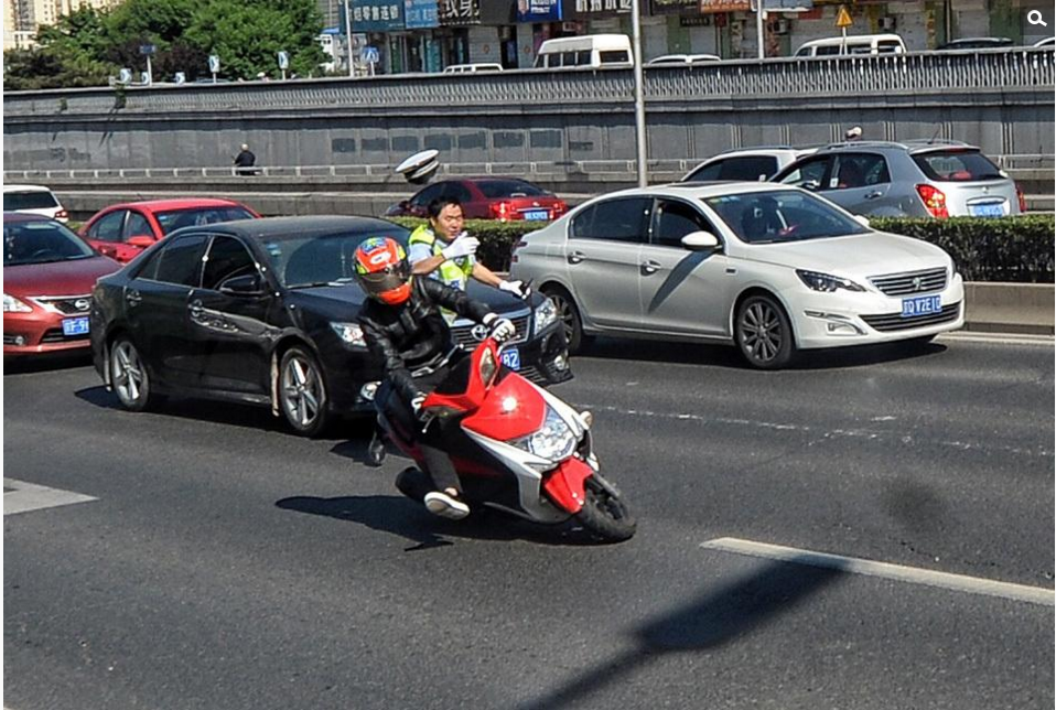 北京交警整治违规上路摩托车 车主闯卡倒地