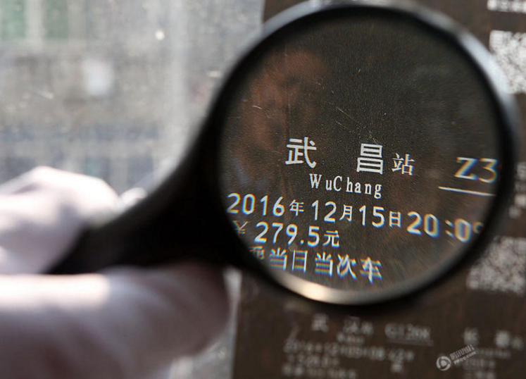 　　武汉铁路公安局武汉公安处刑警正在展示清缴制作假火车票的胶带。