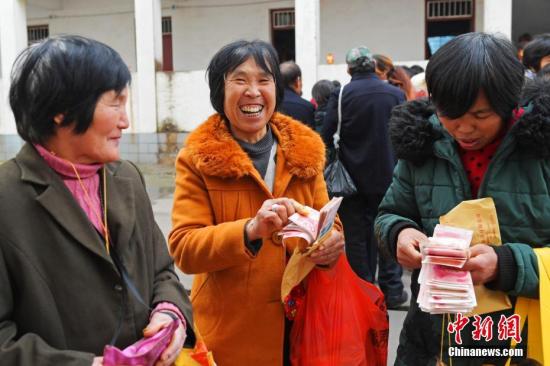 资料图：1月13日，在湖北宜都一家公司打工的农民工，高兴地领到了工资。曹礼达 摄