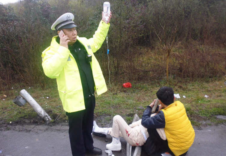 　　2月3日，江苏省镇江市，接到出警指令，闻听有人受伤，镇江高速一大队民警巫益民当即丢下碗筷直奔现场。4日，记者从镇江高速一大队了解到，巫益民到场后，面对等待救护车的女伤者，他又紧急充当临时“输液杆”。不仅在风雨中坚持20分钟，期间还要指挥交通。