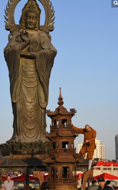 寺庙的工作人员在清理香客扔在庙里的硬币及纸币。